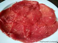 Carpaccio con lascas de queso parmigiano Reggiano y cebolla caramelizada