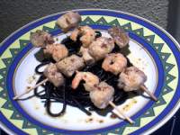   Brochetas de pescado con spaguettis negros